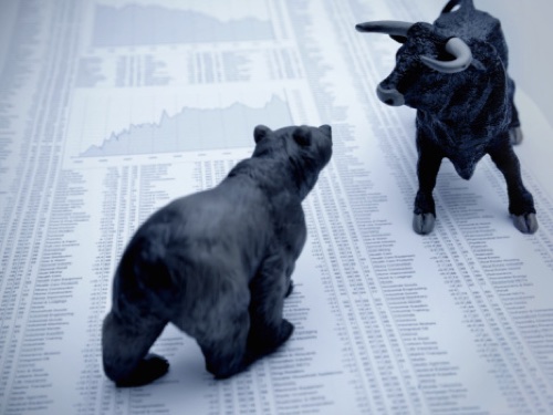 Bull and bear figures on a newspaper