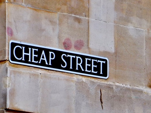 A sign on a wall reading cheap street