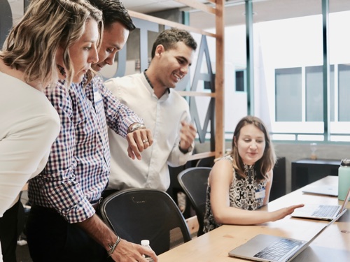 A group of people in front of a computer