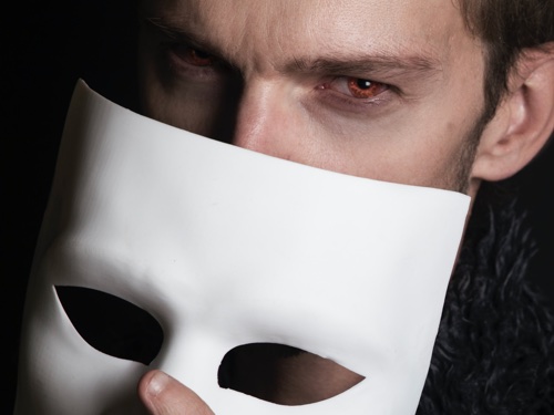 A man holding a mask in front of his face